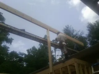 Carpenter setting a ridge beam over a new addition frame — Ice Dam Removal by Roofing Brothers in Palmerton