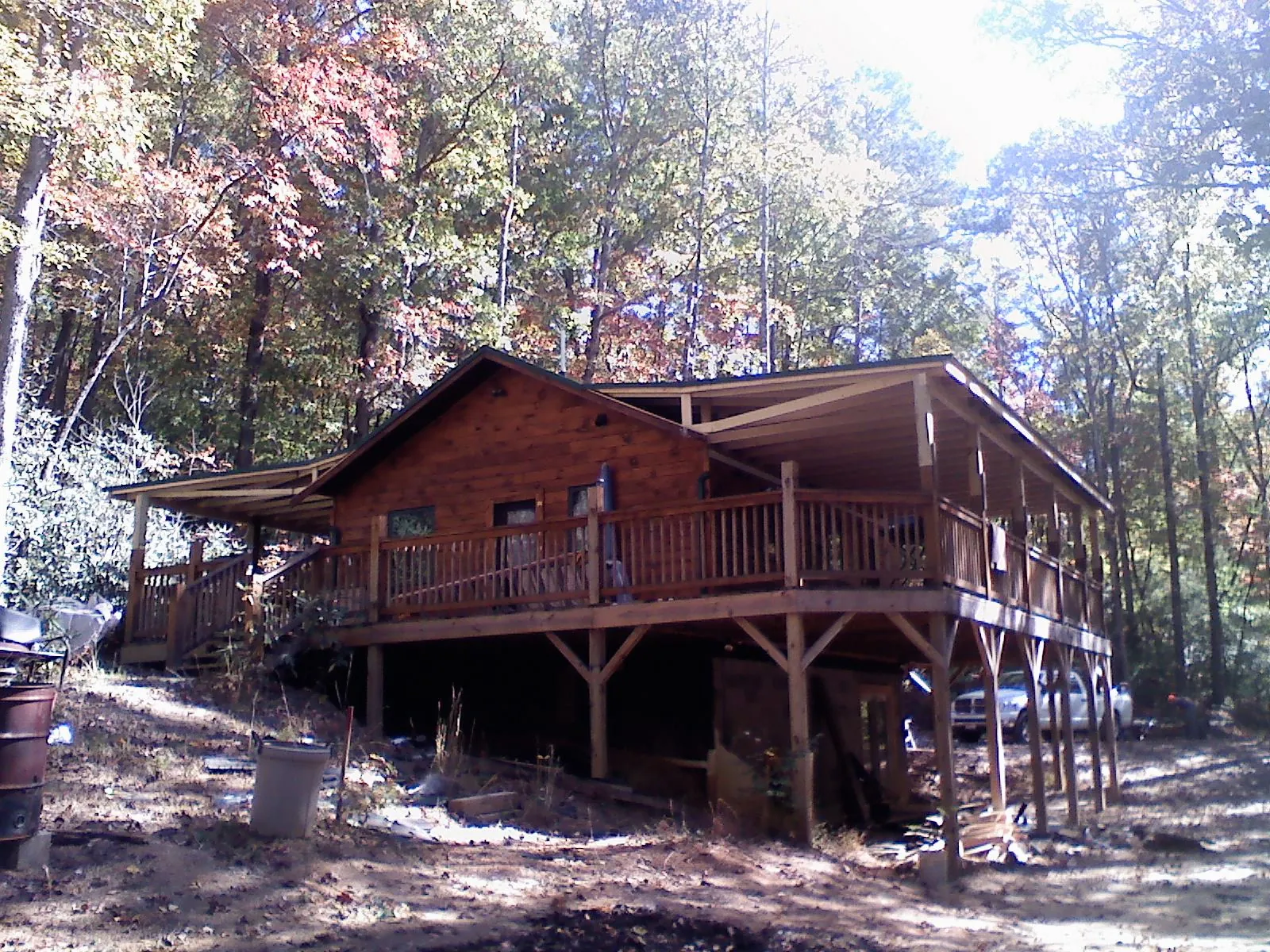 Log cabin with a wraparound porch and metal roof in the fall in Palmerton