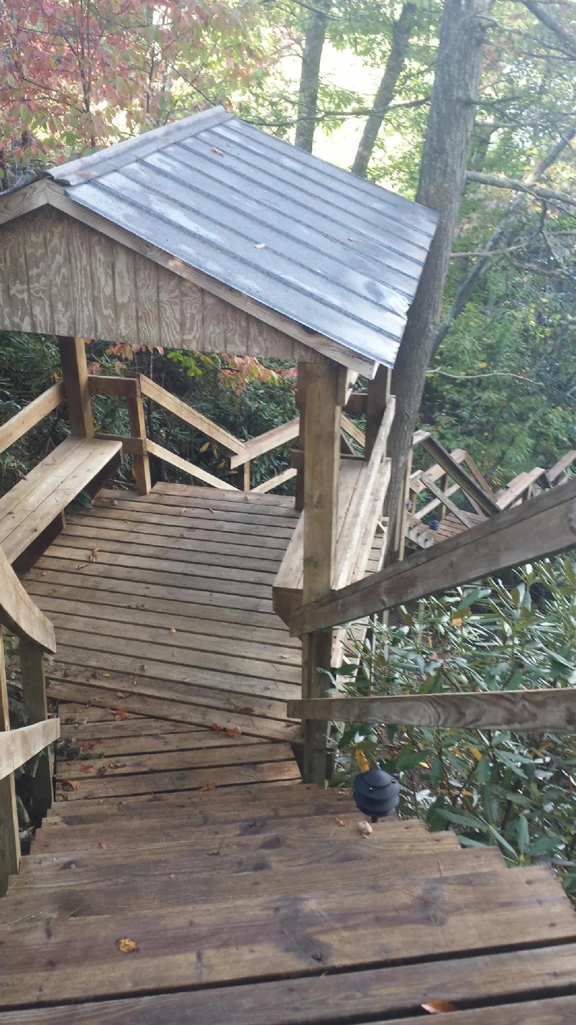 Metal roofed shelter over wooden steps on a wooded walkway — Skylight Repair & Installation work by our crew in Palmerton
