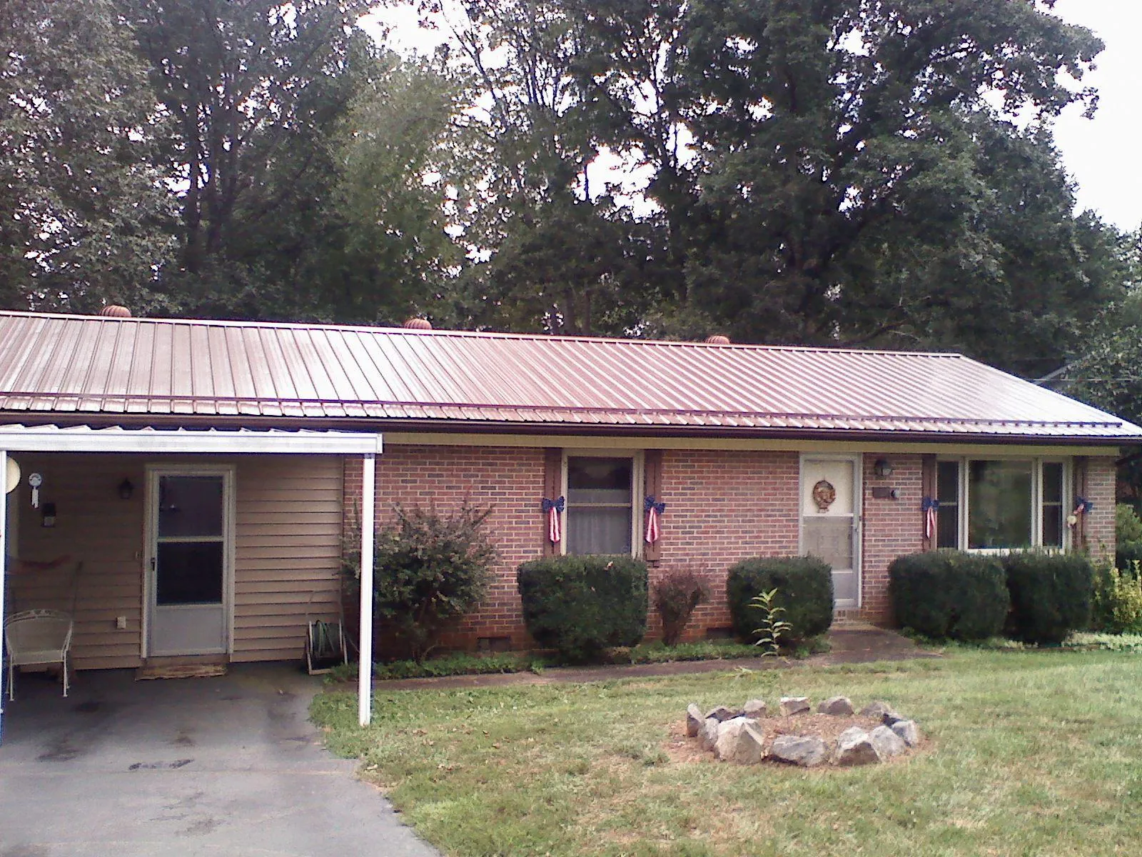 Bronze metal roof and carport on a brick ranch home — Roof Repair work by our crew in Palmerton
